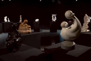 多件雕塑作品陳列於昏暗的展廳中